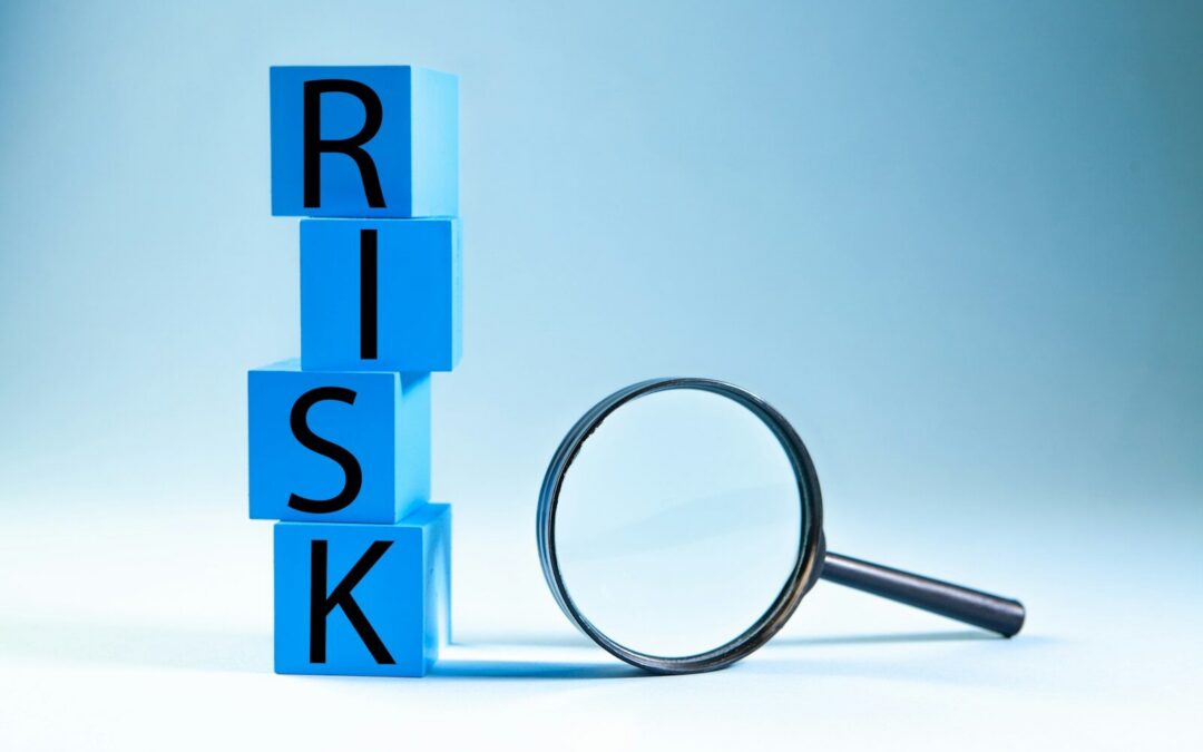 Blue blocks spelling risk next to a magnifying glass.